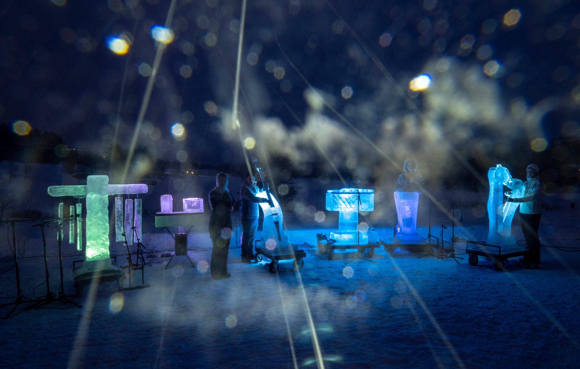 Neljä muusikkoa seisoo talviyössö jäisten soittimien vieressä. Kameran linssi on jäässä.