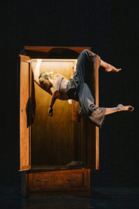 Nainen roikkuu kaapinovessa.